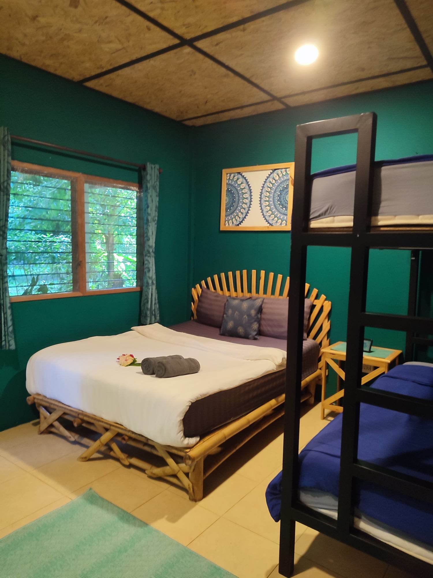 A bungalow room with a double bed and a bunk bed