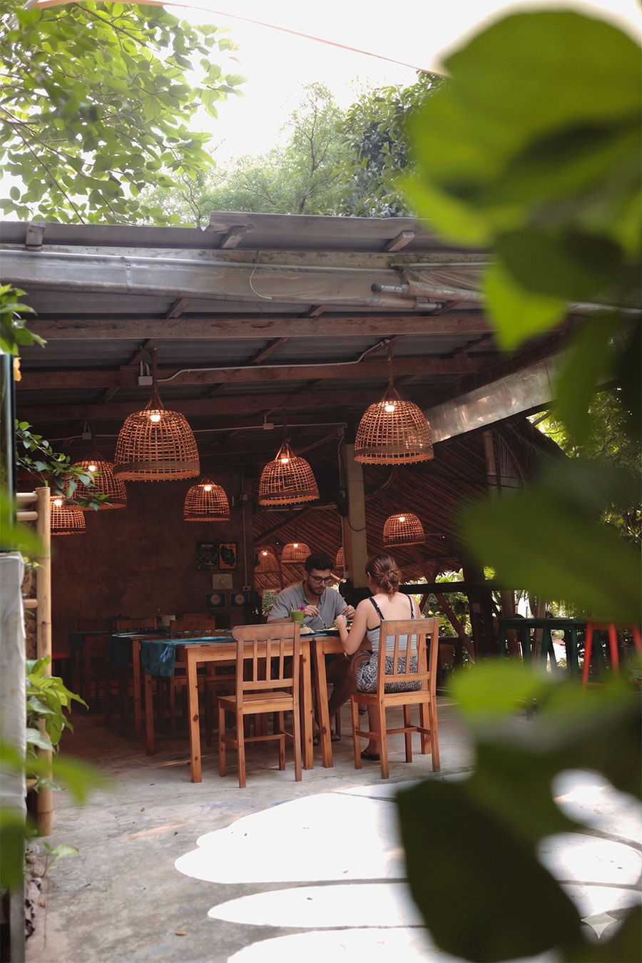The open-air Bliss Restaurant under woven lamps