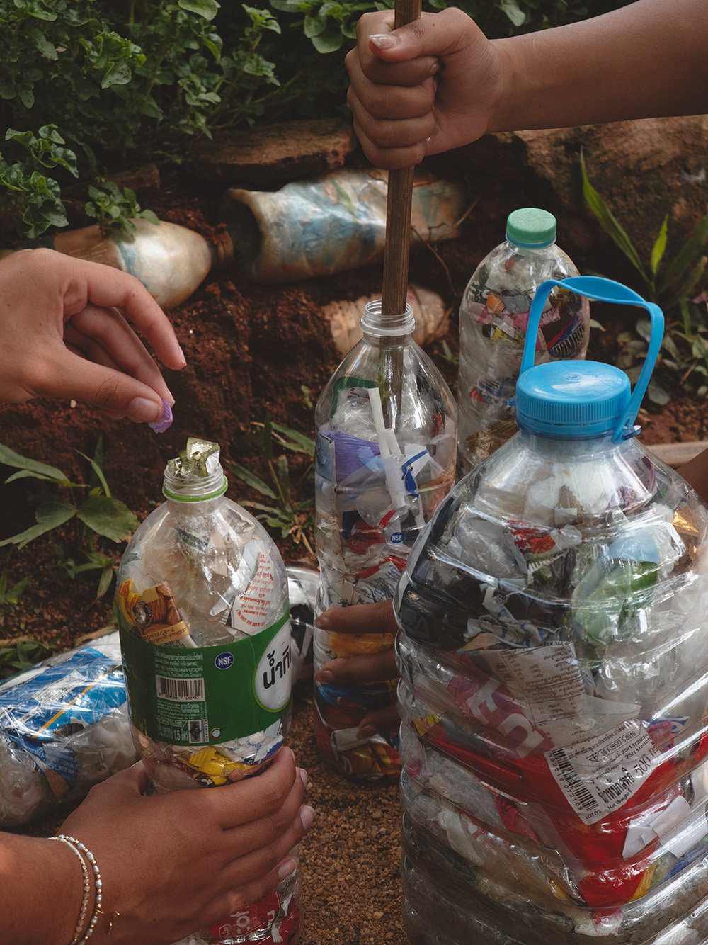 Plastic bottles being packed into eco-bricks